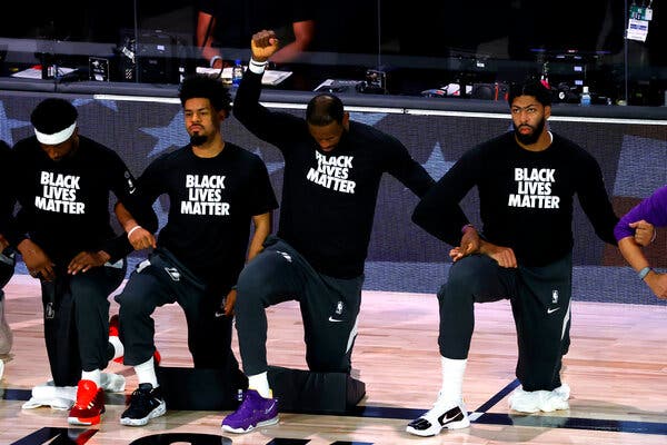 Los Angeles Lakers players kneel for the national anthem.