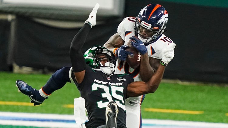 Broncos Rookie, Jerry Jeudy, catches the ball over Jets player, Dominique Williams 