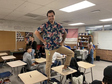 Nate Flack stands on the desks in his classroom.